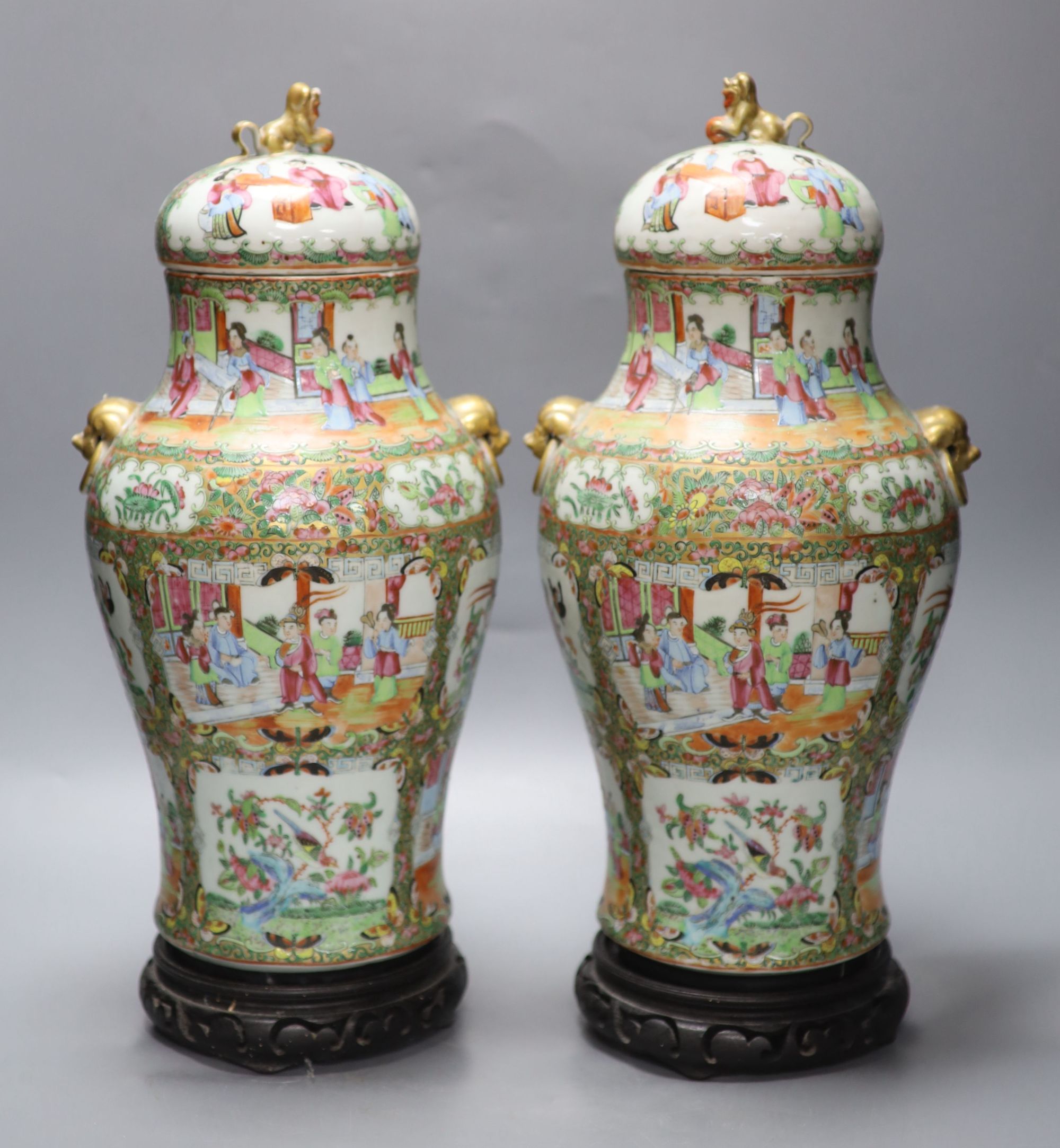 A pair of 19th century Cantonese vases and covers, with later stands, overall height 44cm (a.f.)